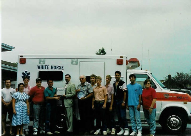 Ambulance 4-9's crew accepts the state Voluntary Ambulance Service Certification, July 9, 1991. Chief Parmer is in the middle of the group, holding the decal.